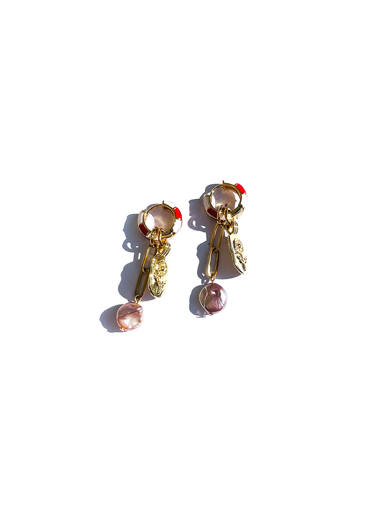 Minimal background showcasing colourful earrings with red and white enamel and unique pearl drop - top view 